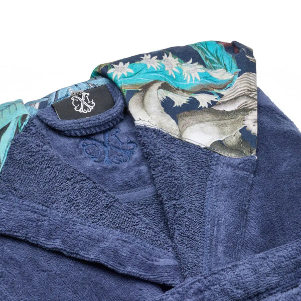 Peignoir de bain en tissu éponge bleu marine avec un col brodé contrastant orné d'un motif floral et d'oiseaux complexe en teal, blanc et gris.